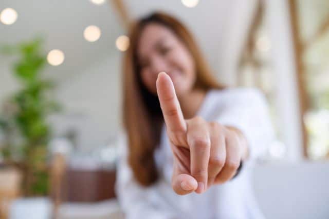 人差し指を向ける女性