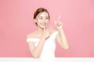 横を指さす女性